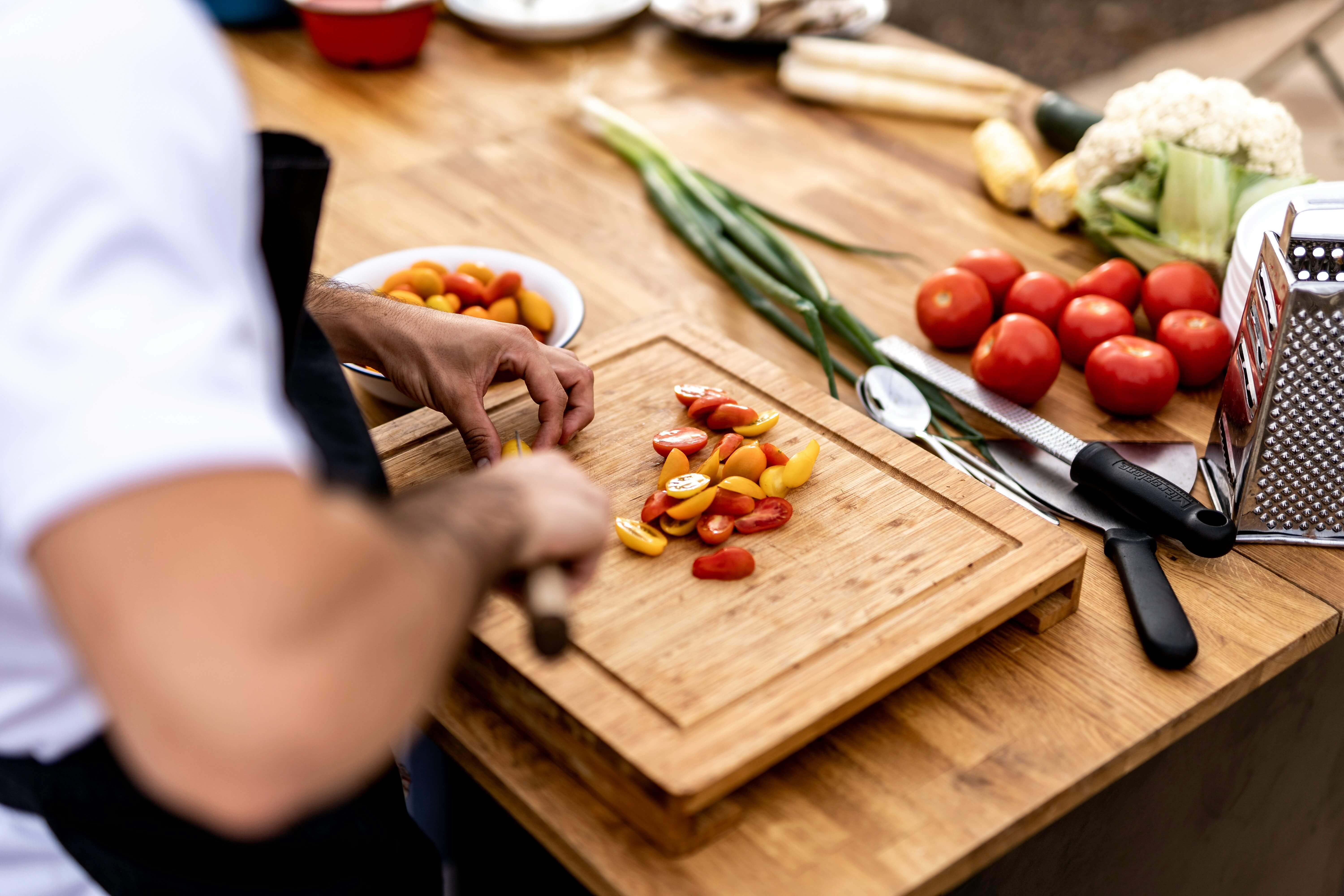 Fresh cilantro and herbs being chopped on a light cutting board